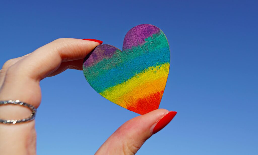 Hand holding a rainbow-colored hear
